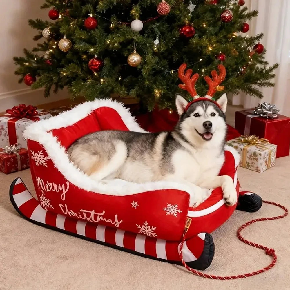 Dog lying on a Christmas-themed dog bed with reindeer antlers in front of a decorated Christmas tree.